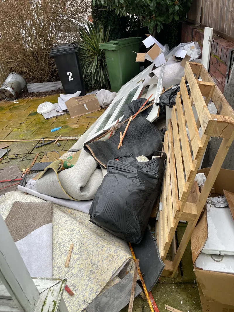 A pile of mixed household waste ready for removal from a patio